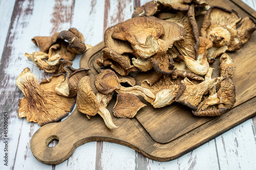 Closeup view of a wooden board with some delicious dried oyster mushrooms on a wooden table.