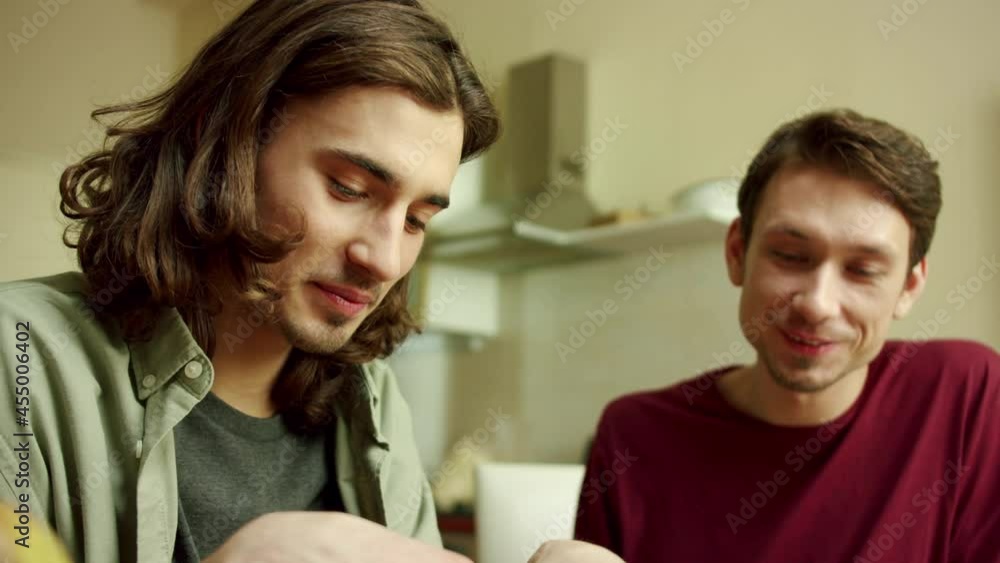 Two lovely men are cooking together and talking 
