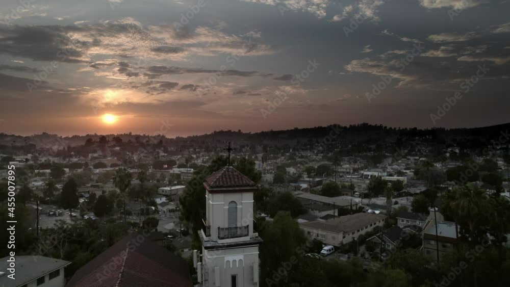 Aerial shot of Spanish architecture church at sunset in the city. Cross silhouette on top of church steeple. Los Angeles, CA Aerial shot of Spanish architecture church at sunset in the city. Cross silhouette on top of church steeple. Los Angeles, CA