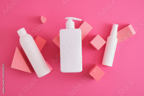 several different white mock up cosmetics bottles on composition of geometric podiums, stands for product