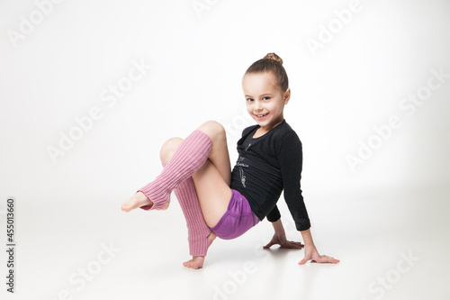 Portrait of a pretty little girl doing gymnastics over white background