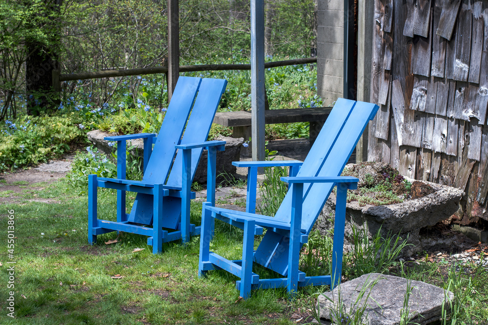 Blue chairs in the country setting invite the viewer to relax and sit a spell