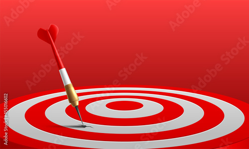 Red dart arrow hitting in the target center of dartboard