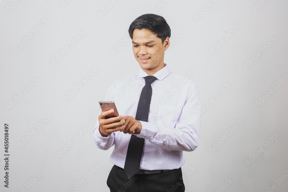 Smiling Asian businessman in white shirt and black tie using smart phone Smiling Asian businessman in white shirt and black tie using smart phone