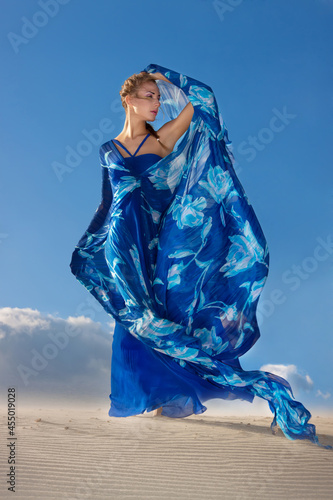 Portrait of a beauty woman in blue dress on the desert