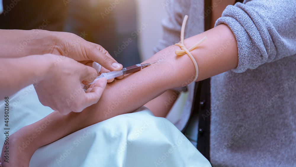 A health worker taking a blood sample from the vein by piercing the veinpumture and collecting blood into a test tube under negative pressurs. A health worker taking a blood sample from the vein by piercing the veinpumture and collecting blood into a test tube under negative pressurs.