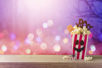 Horror movie night and Halloween party concept with   popcorn on wooden table over scary background