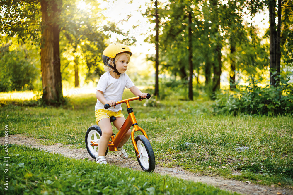 Little cute adorable caucasian toddler girl having fun riding exercise balance run bike push scooter in park forest. Little cute adorable caucasian toddler girl having fun riding exercise balance run bike push scooter in park forest.