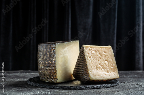 Spanish manchego cheese sliced on dark background. traditional spanish cheese photo
