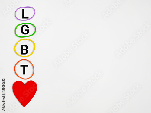 Equality Celebration Concept - LGBT text with colorful band and red heart shaped background. Stock photo.