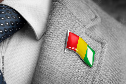 Foto Metal badge with the flag of Guinea on a suit lapel
