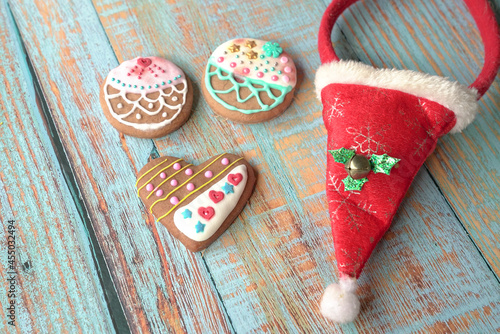 Gingebread cookies on a wood table with santa hat by the side. Top view. photo