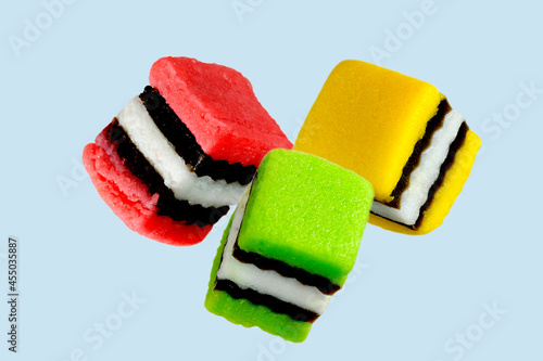 Multicoloured liquorice allsorts isolated on light blue background