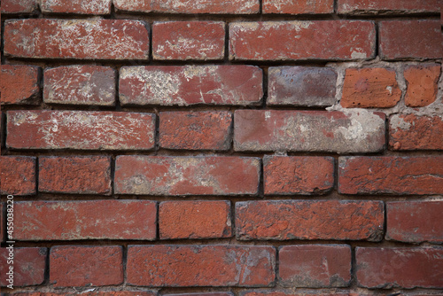 the texture of a red old brick wall with white scuffs.