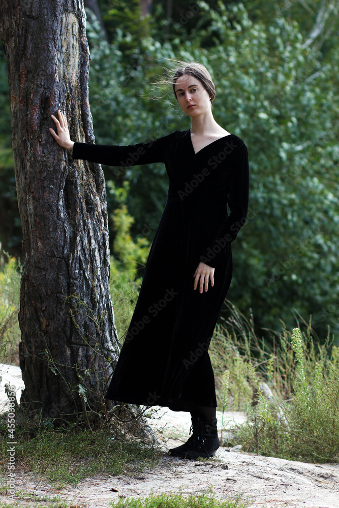 Portrait of woman in classic black dress in the forest Portrait of woman in classic black dress in the forest