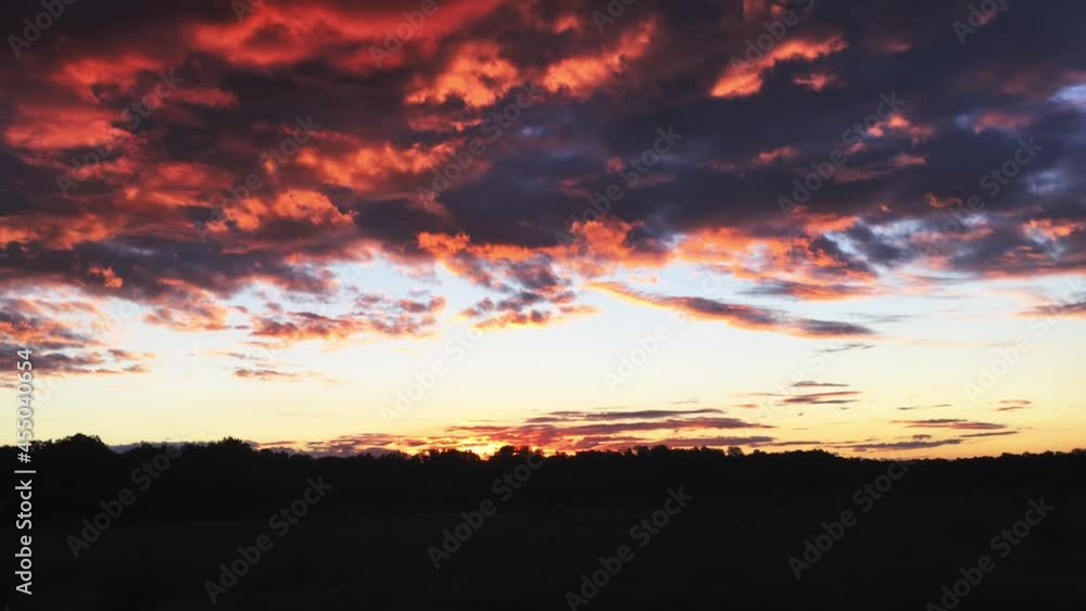 Panorama. dark clouds with a red glow at sunset. twilight on the background of the forest. sun behind the trees Panorama. dark clouds with a red glow at sunset. twilight on the background of the forest. sun behind the trees