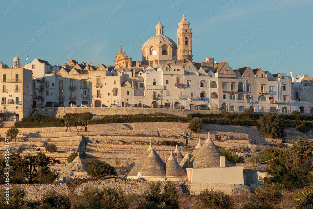 Fototapeta premium Locorotondo, Bari. Veduta con trulli verso la cittadina con la Chiesa madre di San Giorgio Martire