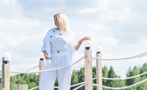 Nice blonde hair woman in cotton suit at golf field. Concept of women's style, fashionable collection