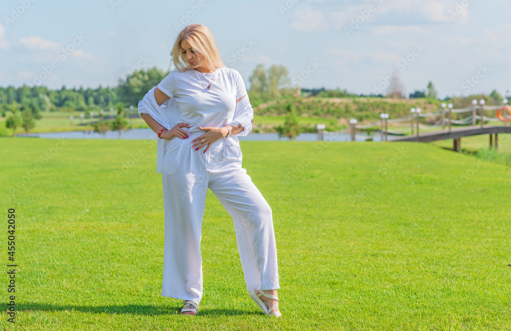 Nice blonde hair woman in cotton suit at golf field. Concept of women's style, fashionable collection Nice blonde hair woman in cotton suit at golf field. Concept of women's style, fashionable collection