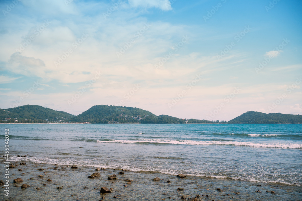 Beach with coconut trees and mountains.View of the coast of the island of island. Beach with coconut trees and mountains.View of the coast of the island of island.