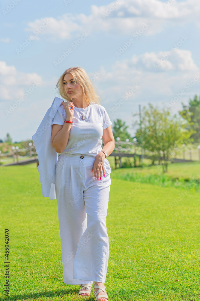 Nice blonde hair woman in cotton suit at golf field. Concept of women's style, fashionable collection Nice blonde hair woman in cotton suit at golf field. Concept of women's style, fashionable collection