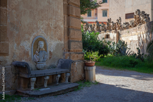 Bagheria, Palermo. Villa Palagonia. Angolo del giardino con panchina e muro con sculture di mostri photo