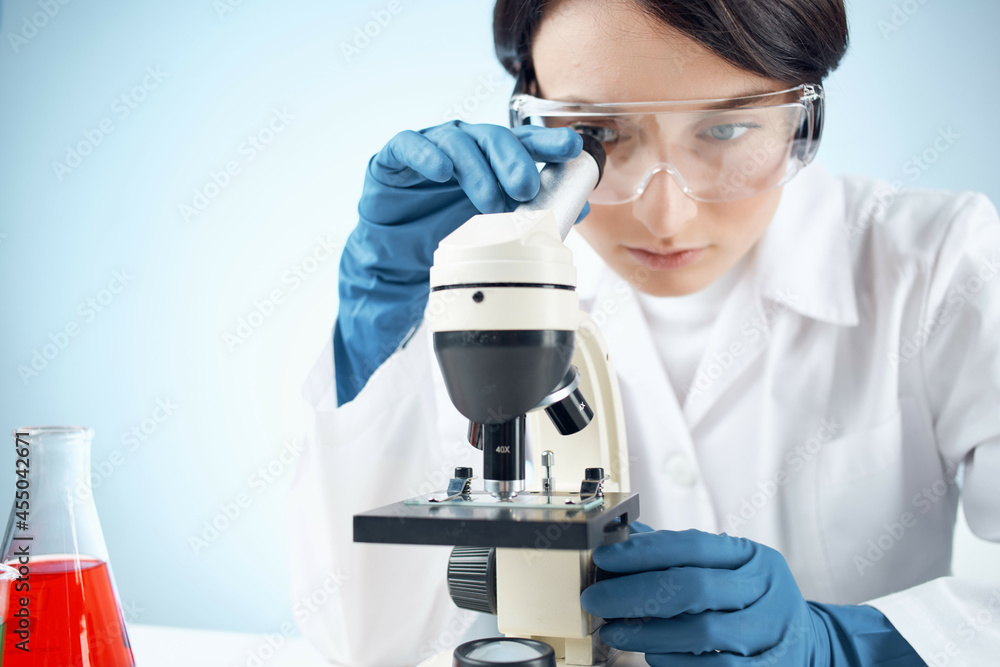 woman looking through a microscope chemical solution laboratory research biotechnology woman looking through a microscope chemical solution laboratory research biotechnology