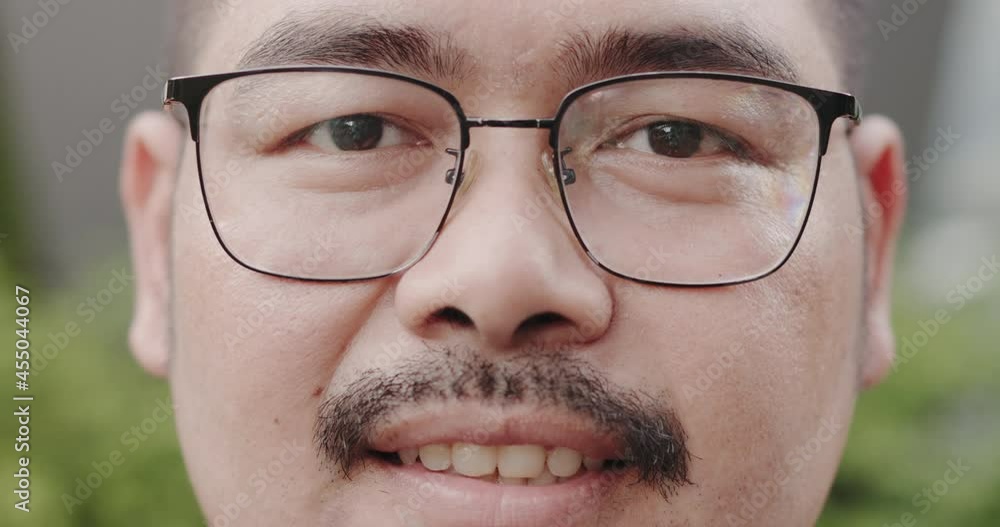 Close up portrait of face Charming Asian man with glasses and mustache smiling confident enjoying success. looking at camera and happy. male positive thinking. obese people health Close up portrait of face Charming Asian man with glasses and mustache smiling confident enjoying success. looking at camera and happy. male positive thinking. obese people health