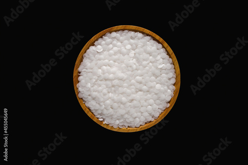 Wax resin on wooden plate. Beads wax pellets background. wax pallet isolated on black background. pe wax. lubricate wax.