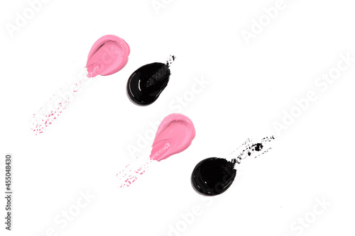 slightly smeared, stretched drops of black and pink acrylic paint on a white background