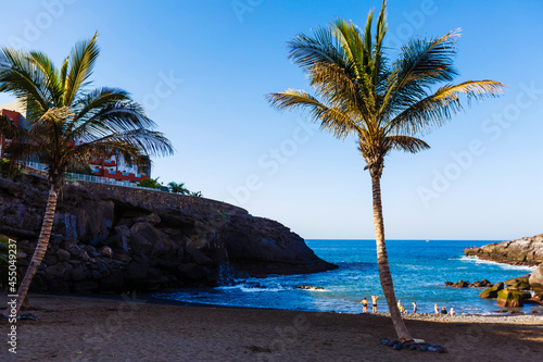 Tropical island of Tenerife. The coast of a Spanish city on the Atlantic ocean. Panorama of the city and beach on the island of Tenerife. Background color with gradient and grain  sound effect