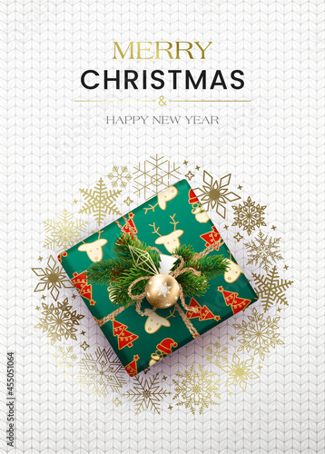 Merry Christmas greetings. Poster with a gift box and a wreath of snowflakes