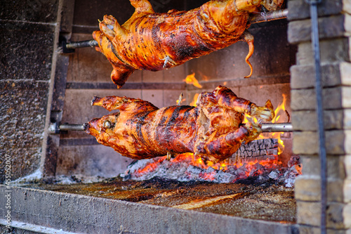 Spanferkel am Holzgrill, drehen am Spies