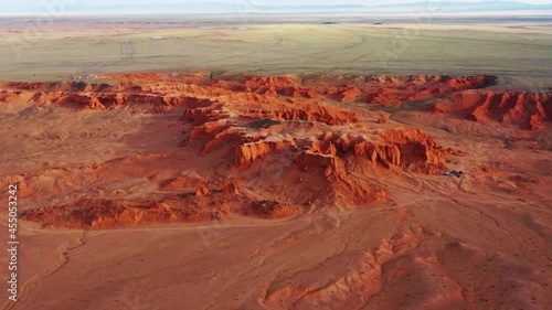 Aerial around view of the Bayanzag flaming cliffs at sunset in Mongolia, found in the Gobi Desert, 4k photo