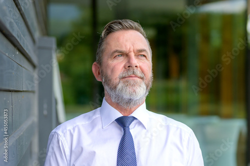 Businessman standing looking thoughtfully to the side