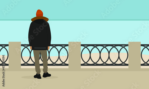 A male character in a jacket and a hat stands on the embankment and looks at the sea