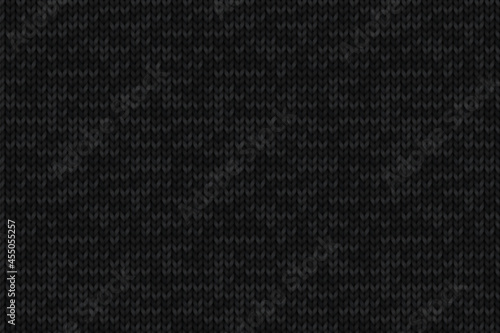 Knitted dark gray background with repeating texture of merino wool. Black seamless pattern with realistic knitwear for wallpaper, winter design, web page backdrop, postcard.