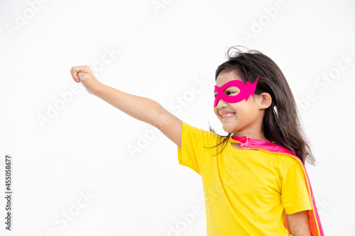 Funny little girl playing power super hero over white background. Superhero concept.