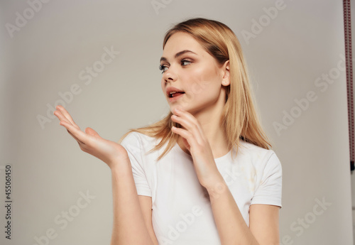 beautiful blonde in a white t-shirt hand gesture isolated background