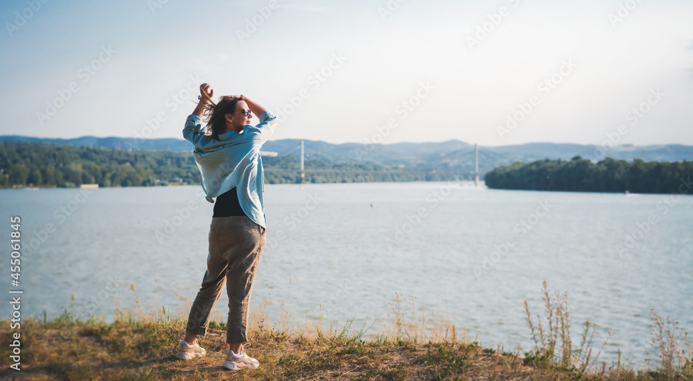 Happy beautiful mid adult woman enjoying view and landscape on the river bank
