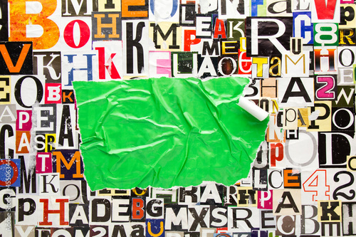 Torn and crumpled piece of green paper on collage from clippings with newspaper magazine letters and numbers. Ripped green paper on alphabet letters cutting from magazine. Copy space for text.