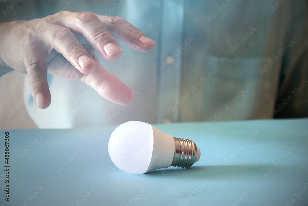 Energy saving concept with light bulb and hand. Copy space. Selective focus. Energy saving concept with light bulb and hand. Copy space. Selective focus.