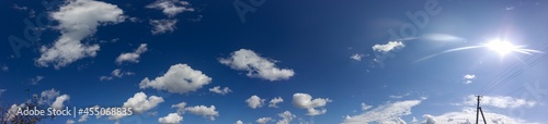 Panorama of the sky. Fluffy clouds with the sun.