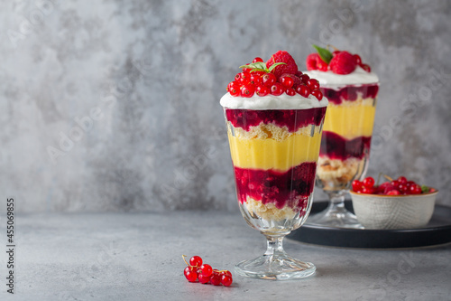 Tableau sur toile Individual size Trifles, layered dessert in glass with berry jelly, custard,  sponge and whipped cream, decorated with fresh berries