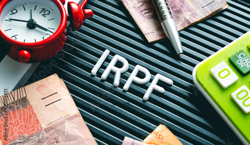 IRPF - Imposto de Renda da Pessoa Física. Economia brasileira. Palavra IRPF formada em uma quadro com letras e uma moeda de 1 Real. Dinheiro, Brasil e Economia. photo