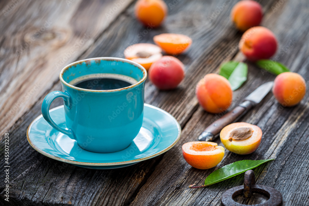 Blue coffee and orange plums on wooden table Blue coffee and orange plums on wooden table