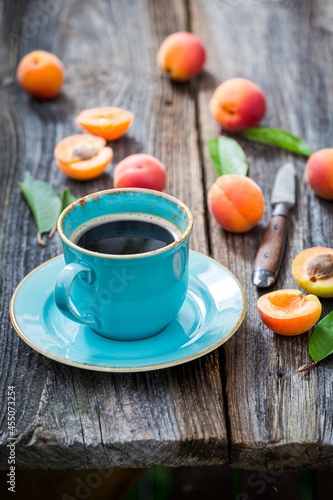 Delicious coffee and plums on wooden table