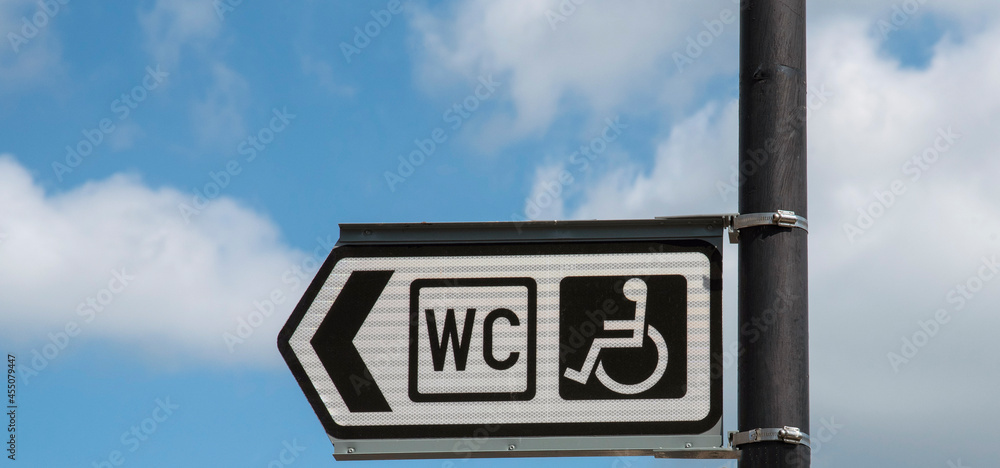 Cornwall, England, UK. 2021. A black and white sign and arrowing pointing to a public diasabled toilet for wheelchair occupants use. Cornwall, England, UK. 2021. A black and white sign and arrowing pointing to a public diasabled toilet for wheelchair occupants use.