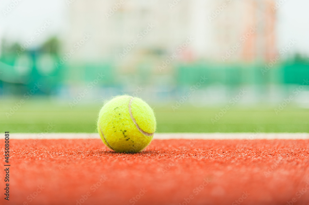 Tennis ball on the court in soft focus. Photo with copy space.