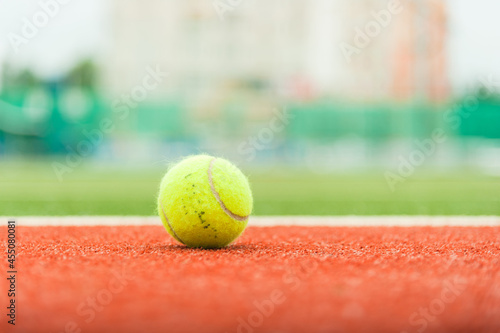 Tennis ball on the court in soft focus. Photo with copy space. © yallowww